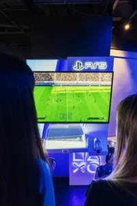 PS5 huren voor je evenement: gamers spelen een voetbalgame op groot scherm