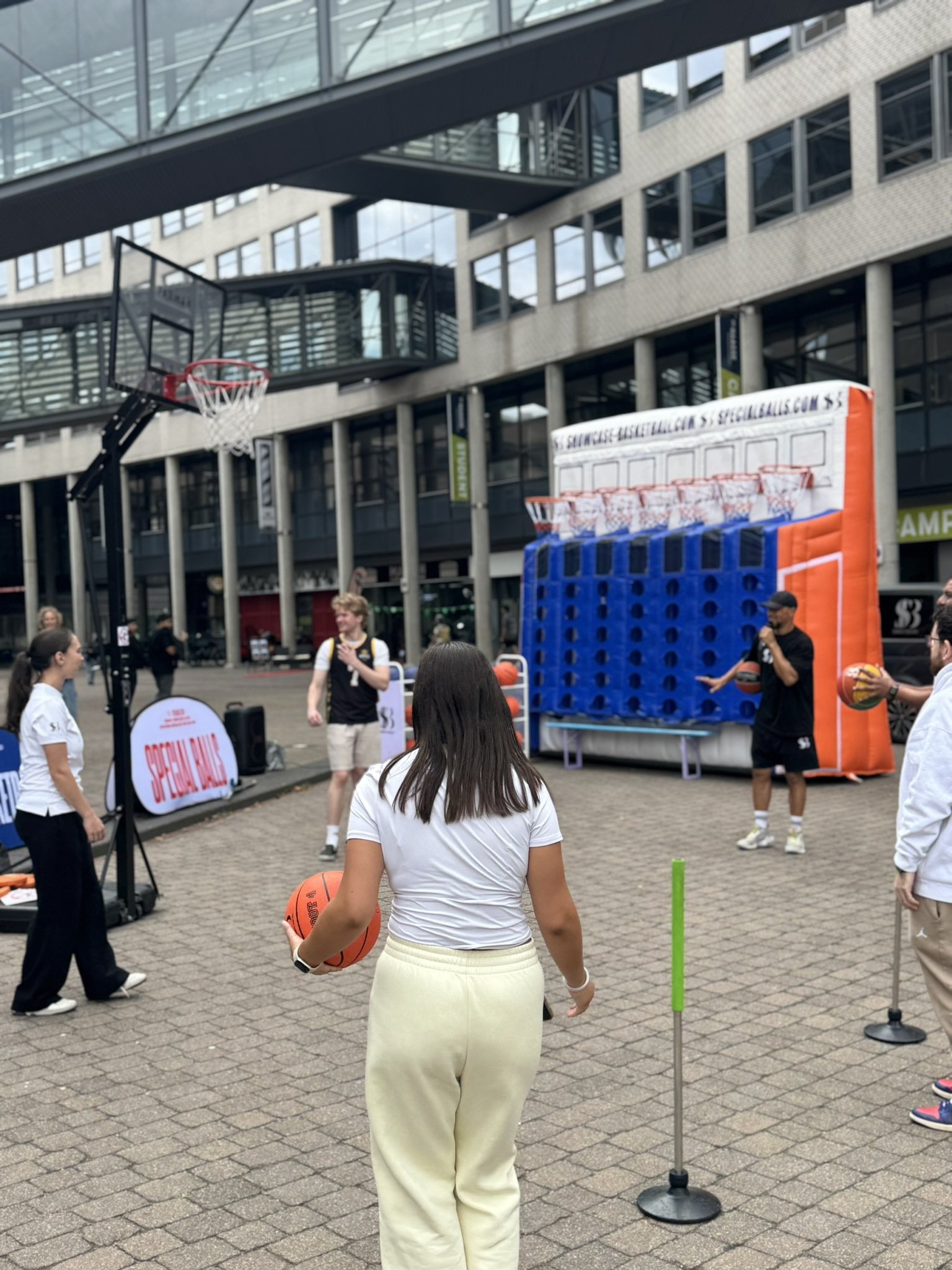 Studente loopt met een basketbal naar de opstelling van Showcase Basketball op De Haagse Hogeschool