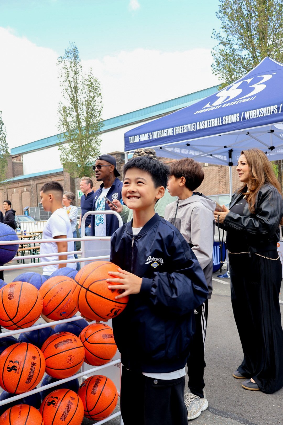 Lachende jongen met een basketbal bij de stand van Showcase Basketball op RSCW 2026