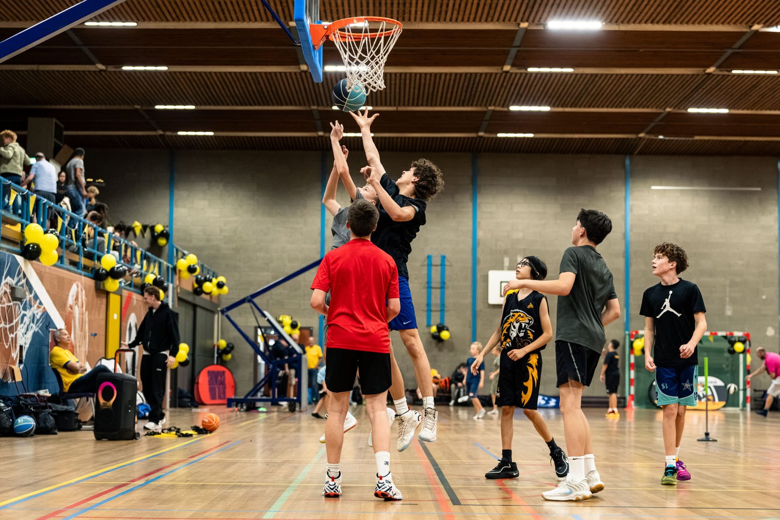 Actie op de vloer met een volle tribune op de achtergrond bij BV Alphia