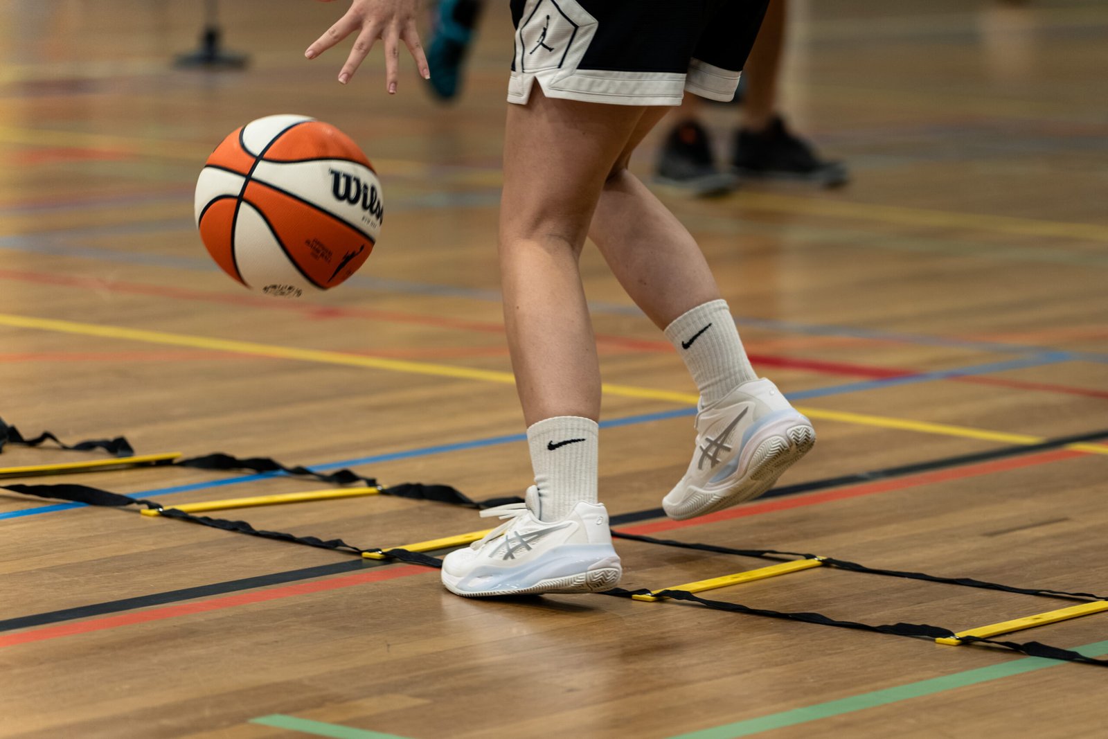 Close-up van voetenwerk met bal op de houten vloer van de zaal