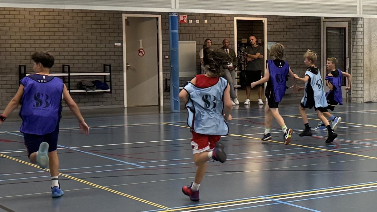 Jonge spelers in hesjes van Showcase Basketball tijdens de seizoensopening van BV Oegstgeest