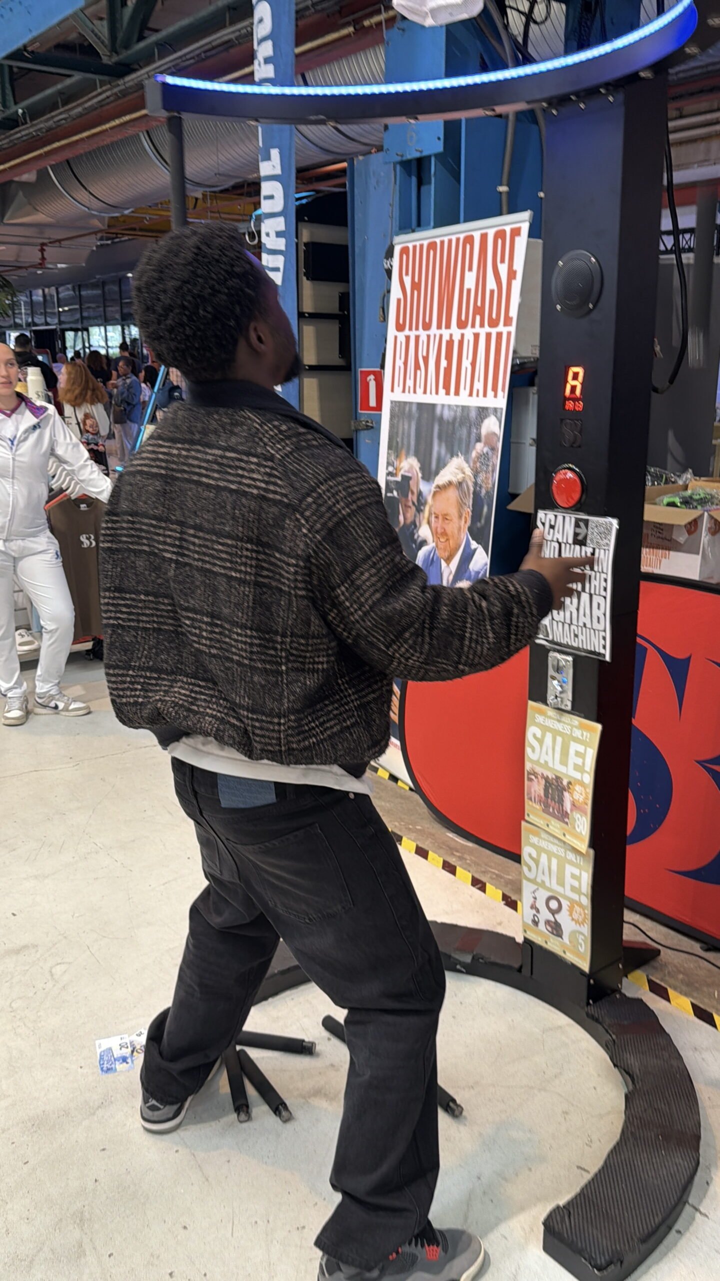 Bezoeker probeert de reactiemachine bij de stand van Showcase Basketball