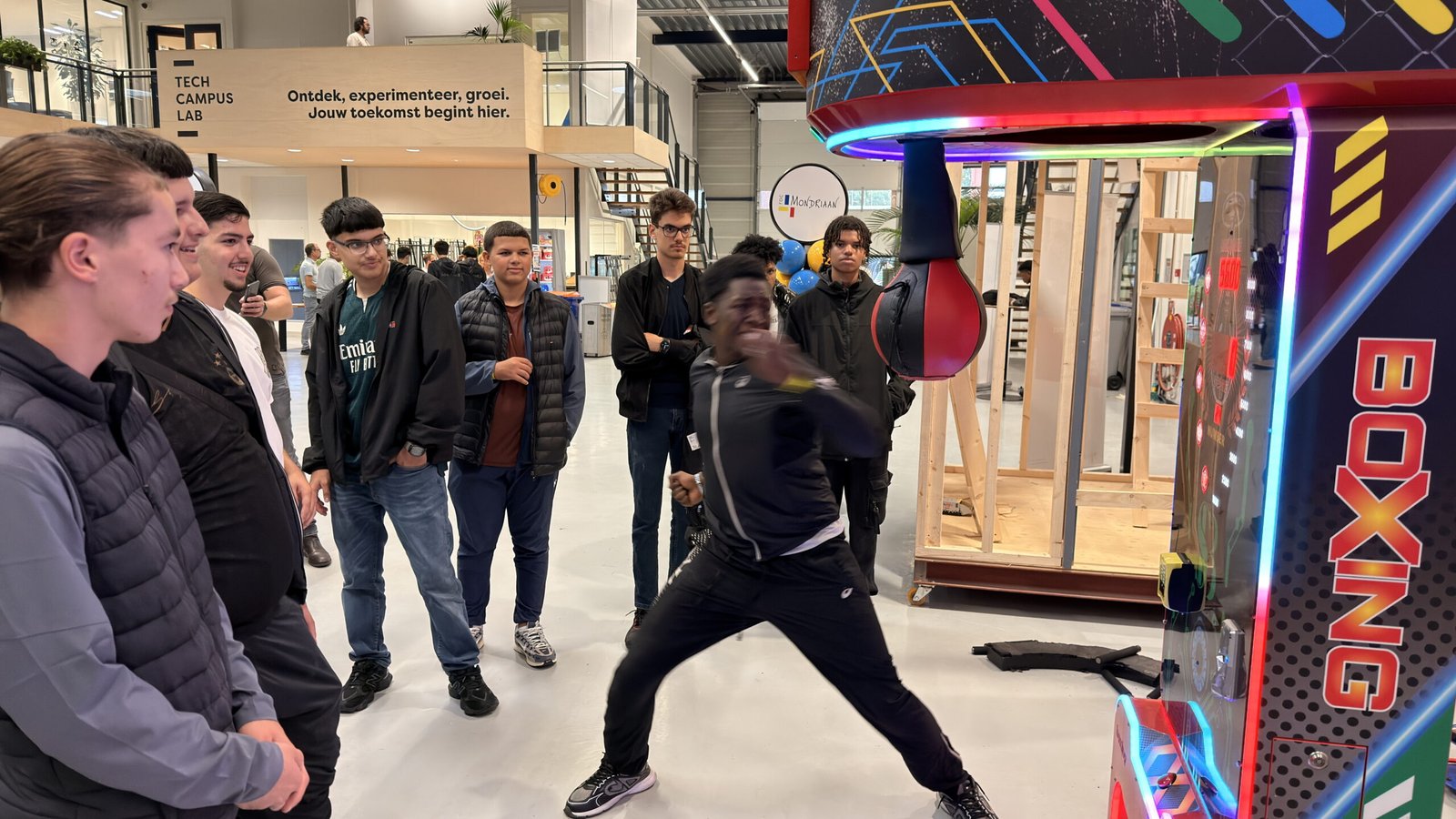Leerlingen kijken toe terwijl de boksmachine wordt uitgeprobeerd in het atrium