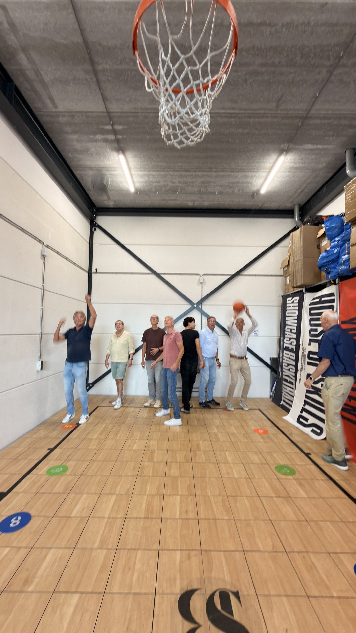 De Zwetende Heren schieten vrije worpen in de basketbalhal van het Experience Center