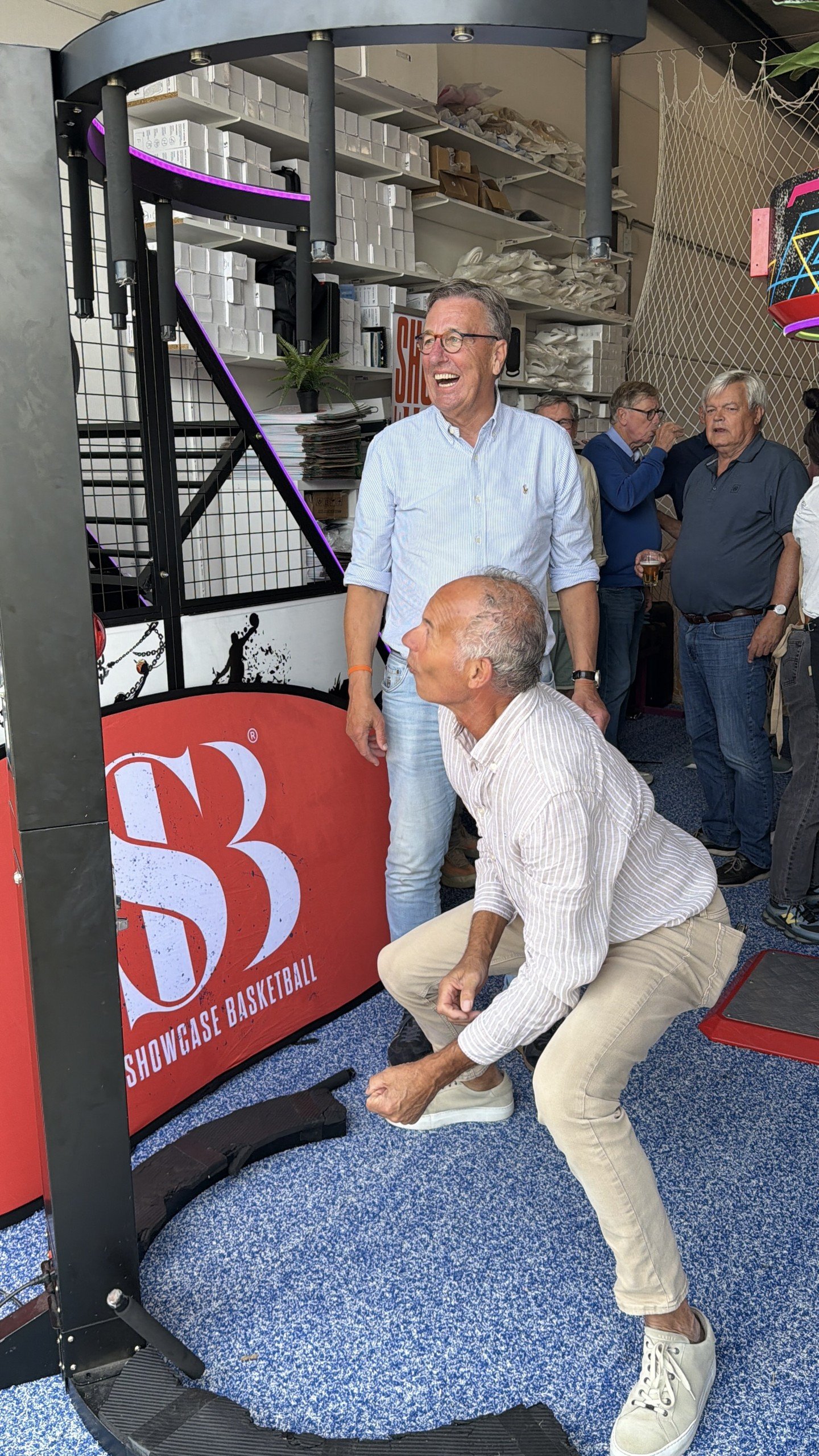 Een gast speelt lachend op de reactiemachine van Showcase Basketball