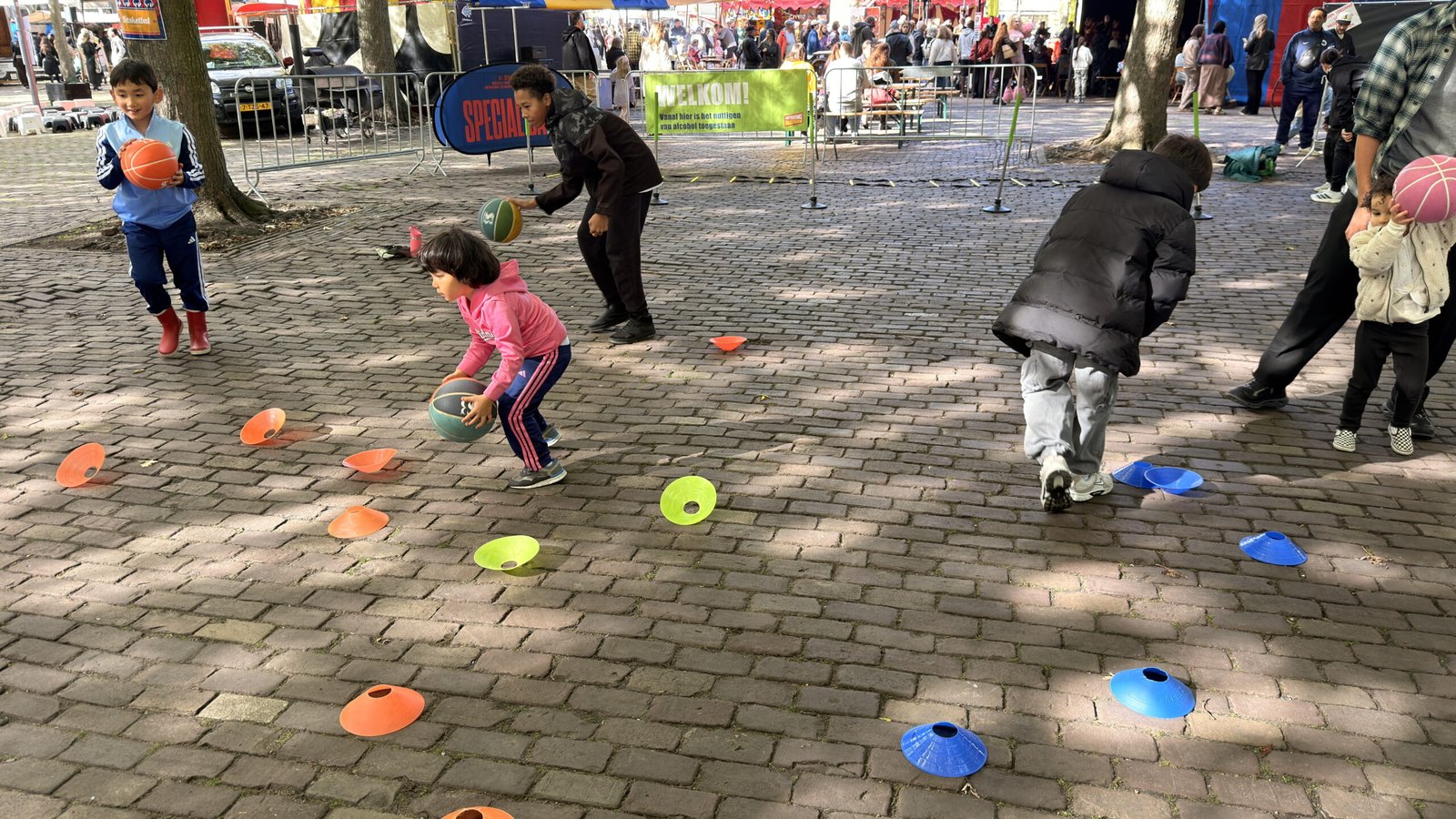 Kinderen dribbelen tussen de pionnen op het Noordplein