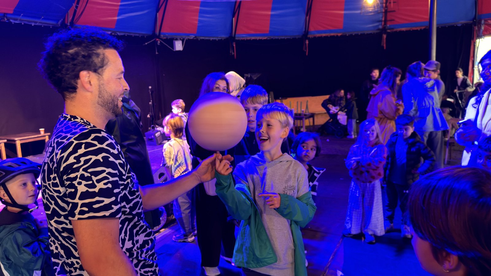 Lachende jongen laat de bal op zijn vinger draaien na de show